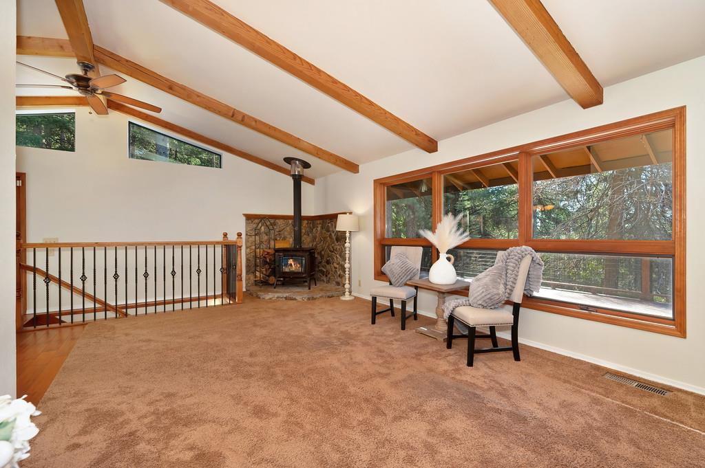 575 Frost Hill Road Alta, CA 95701 - Photo 2 of 82 Living Room: Wood Stove nested on stone. The Wood Stove has been cleaned and not used since the cleaning. The staircase railing you see near the woodstove leads down to the finished basement area.