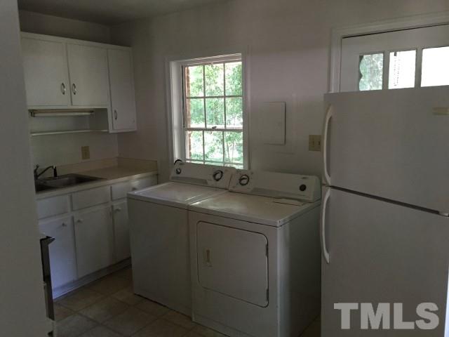 216 Colleton Road Raleigh, NC 27610 - Photo 4 of 11 a utility room with cabinets washer and dryer