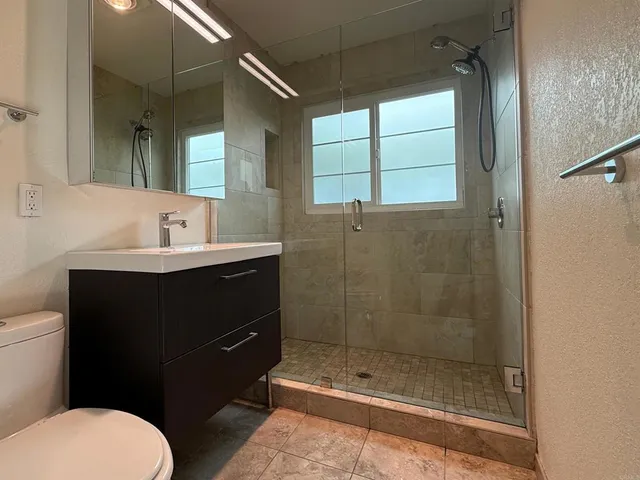 a bathroom with a sink a toilet and shower