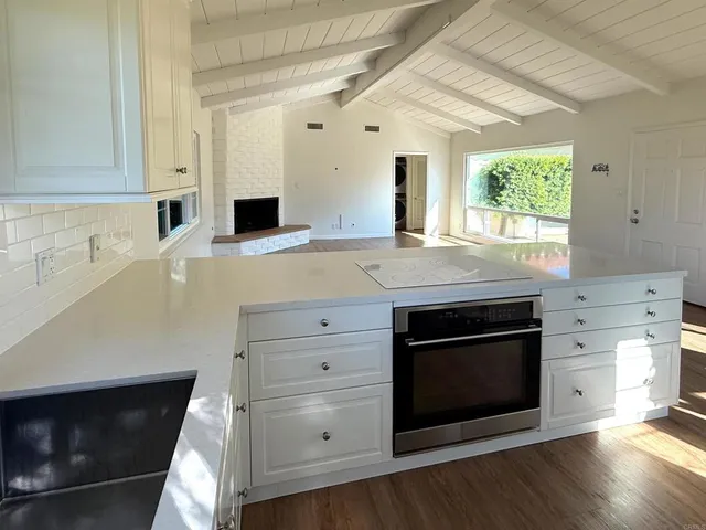 a kitchen with granite countertop a stove fireplace and a microwave