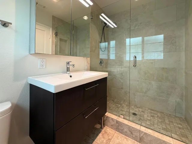 a bathroom with a sink mirror and shower