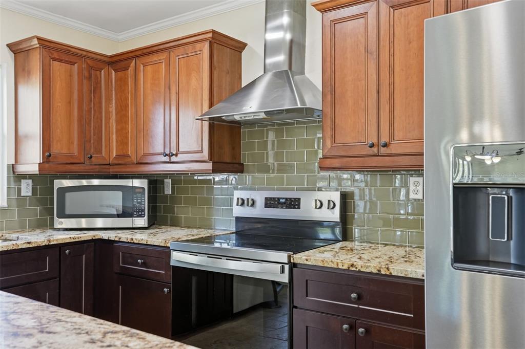 5995 South Shadytree Path Homosassa, FL 34448 - Photo 7 of 64 a kitchen with stainless steel appliances wooden cabinets and a stove top oven