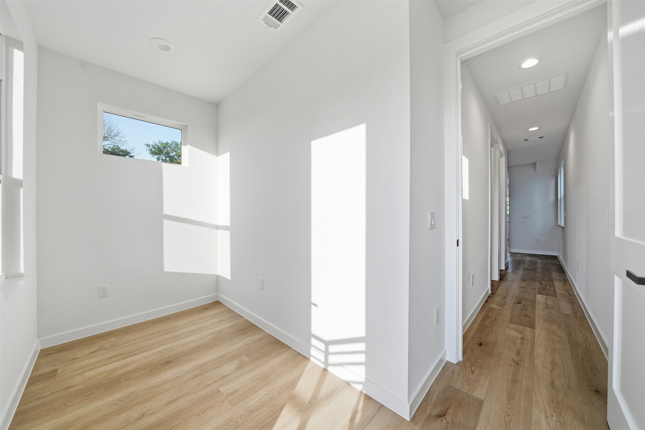 2212 Yellow Jacket Lane, Unit 2 Austin, TX 78741 - Photo 18 of 25 Bright room with light wood-finish flooring, white walls, and a rectangular window