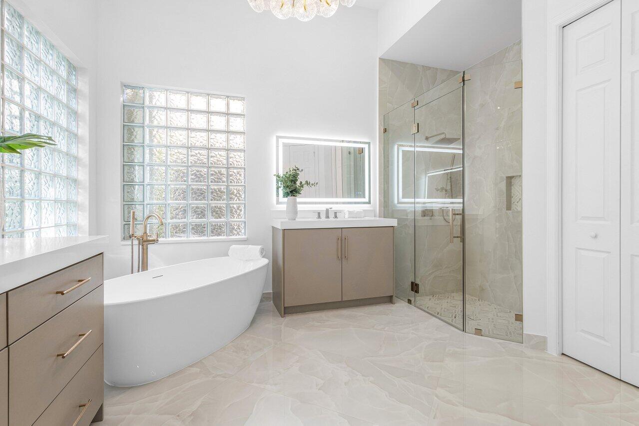8749 Lewis River Road Delray Beach, FL 33446 - Photo 22 of 32 a spacious bathroom with a tub sink and mirror