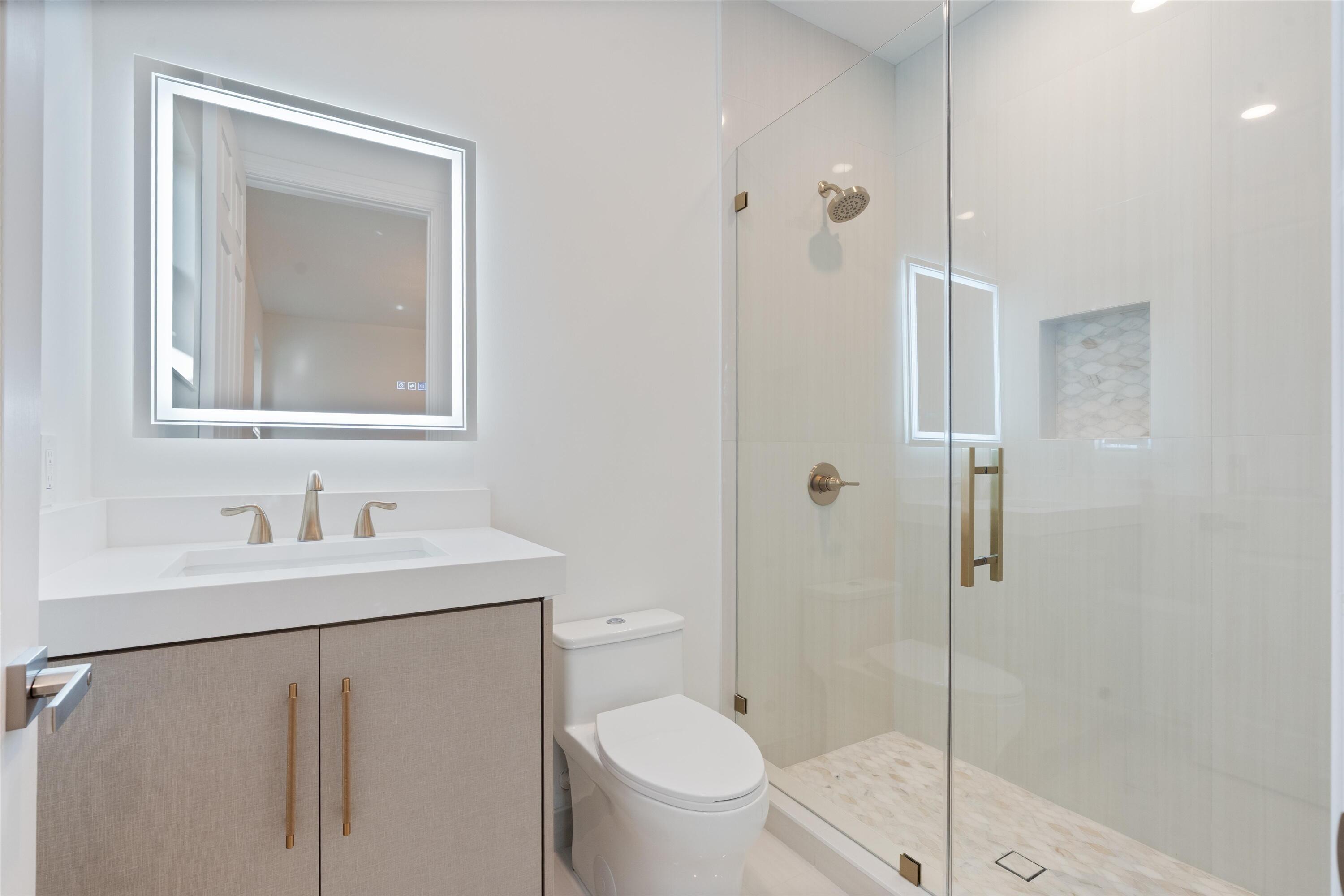 8749 Lewis River Road Delray Beach, FL 33446 - Photo 28 of 32 a bathroom with a toilet a sink a mirror and shower