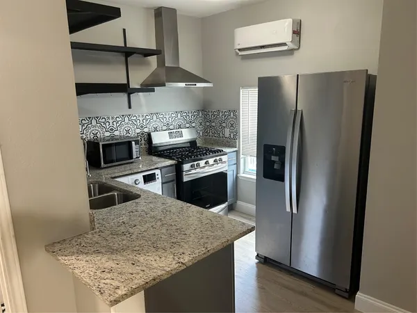 a kitchen with stainless steel appliances granite countertop a refrigerator and a sink