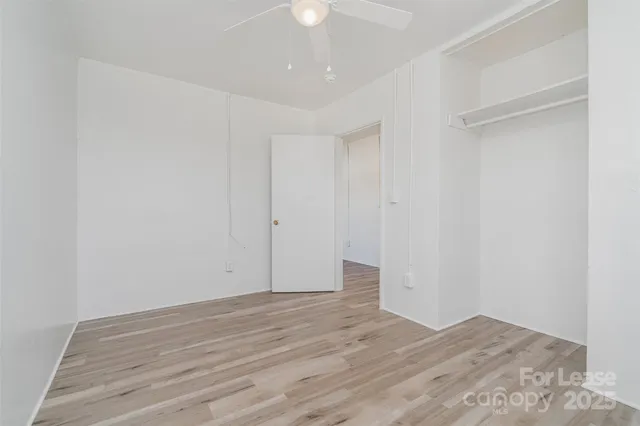a view of room with wooden floor and fan