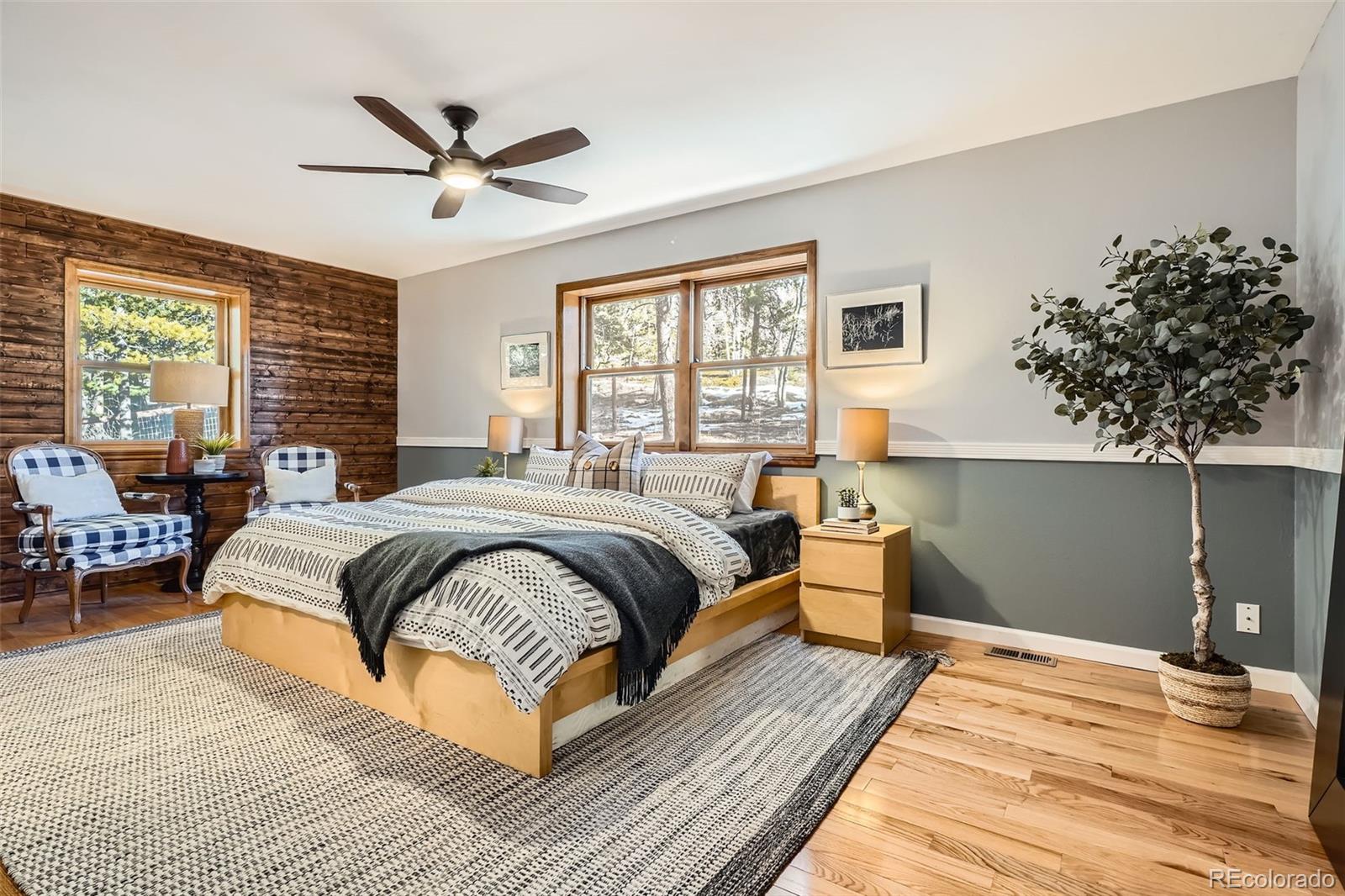 10439 Christopher Drive Conifer, CO 80433 - Photo 11 of 32 a spacious bedroom with a large bed and a chandelier