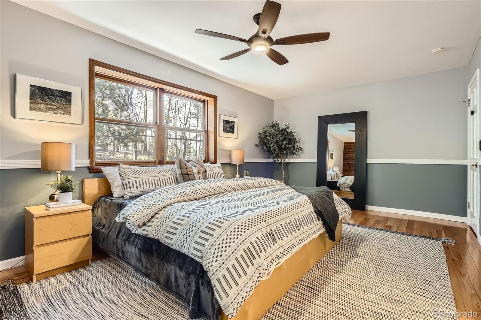 10439 Christopher Drive Conifer, CO 80433 - Photo 12 of 32 a bedroom with a large bed and a chandelier