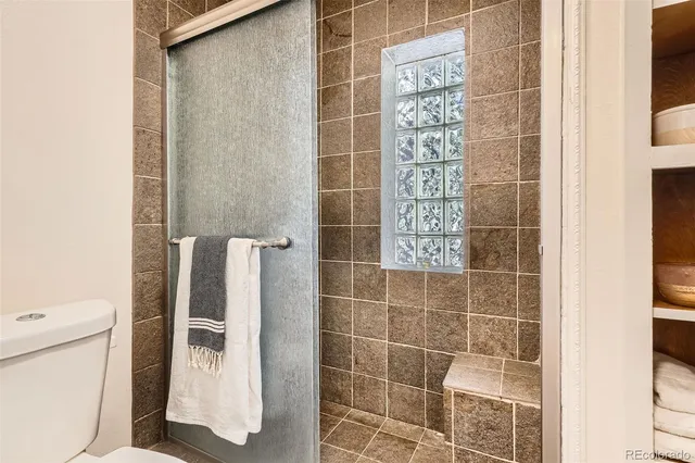 a bathroom with a toilet and a shower