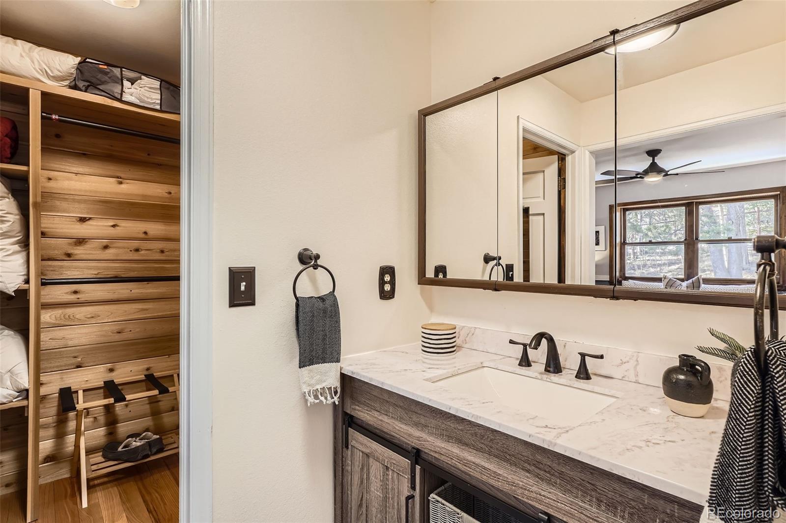 10439 Christopher Drive Conifer, CO 80433 - Photo 14 of 32 a bathroom with a granite countertop sink and a mirror