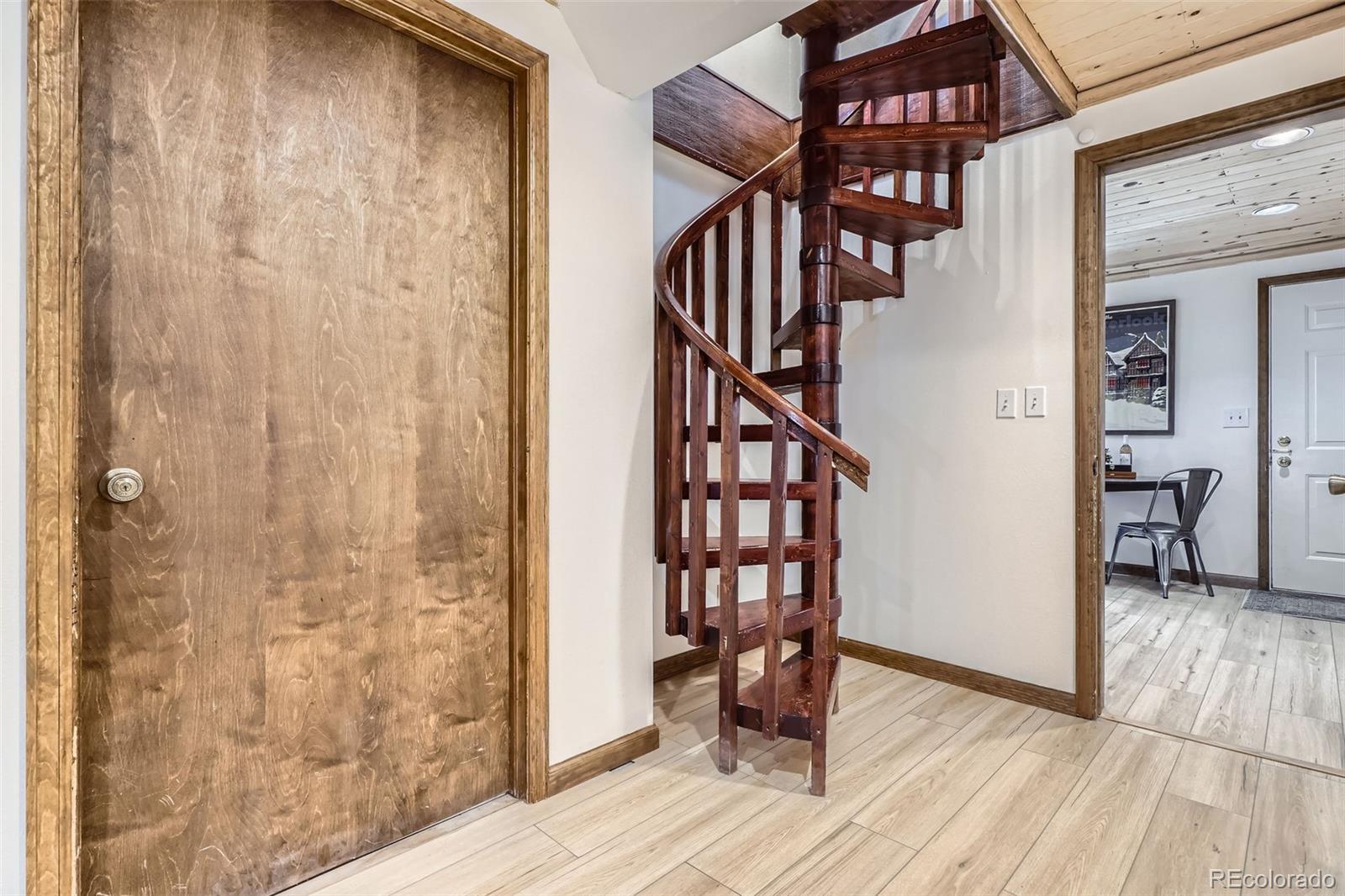 10439 Christopher Drive Conifer, CO 80433 - Photo 23 of 32 a view of a hallway with wooden floor and staircase