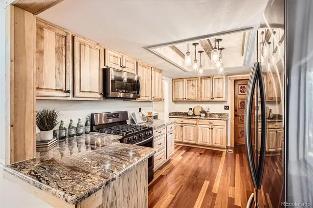 a kitchen with stainless steel appliances granite countertop a stove refrigerator sink and cabinets