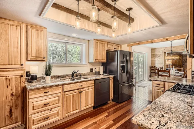 a kitchen with stainless steel appliances granite countertop a refrigerator a stove and a sink