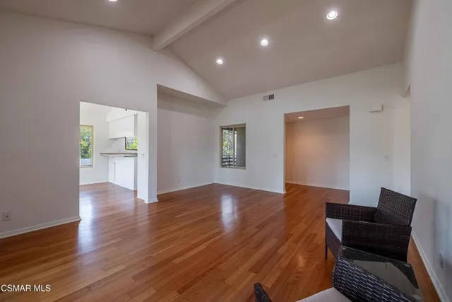 a view of empty room with wooden floor