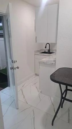 a kitchen with white cabinets sink and dishwasher