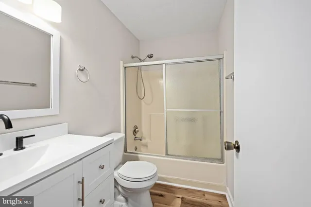 a white toilet sitting next to a white sink and vanity