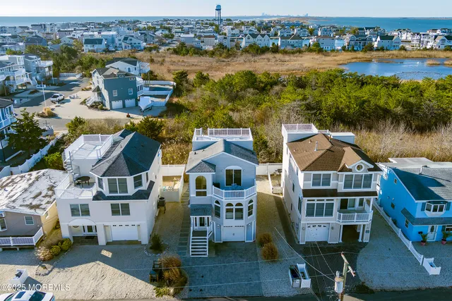 an aerial view of residential houses with outdoor space and lake view