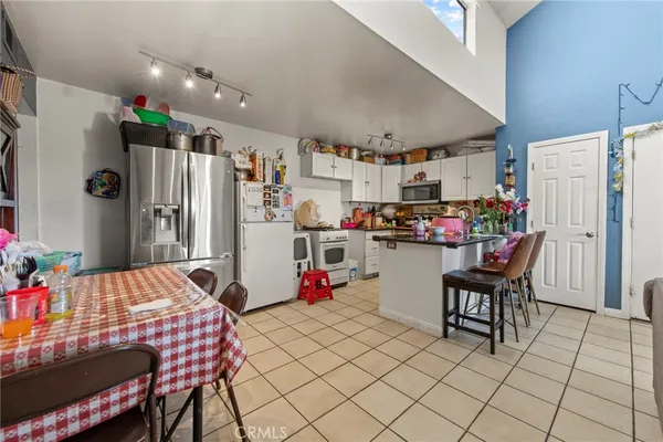 a kitchen with stainless steel appliances kitchen island granite countertop a refrigerator and microwave