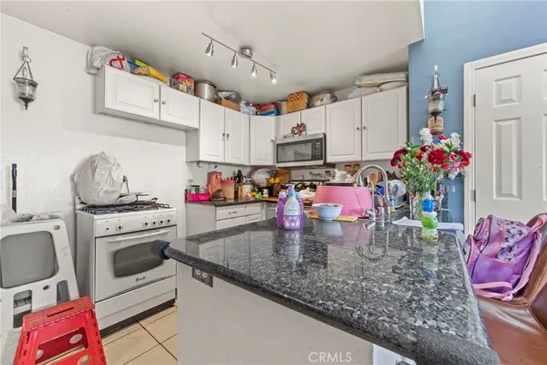 a kitchen with stainless steel appliances granite countertop a sink dishwasher and cabinets with wooden floor