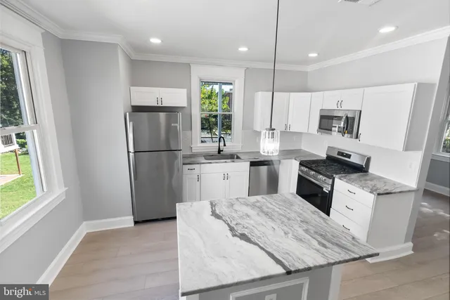 a kitchen with a stove a refrigerator and a window