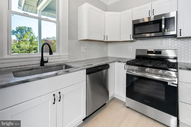 a view of swimming pool with seating area and trees in the background
