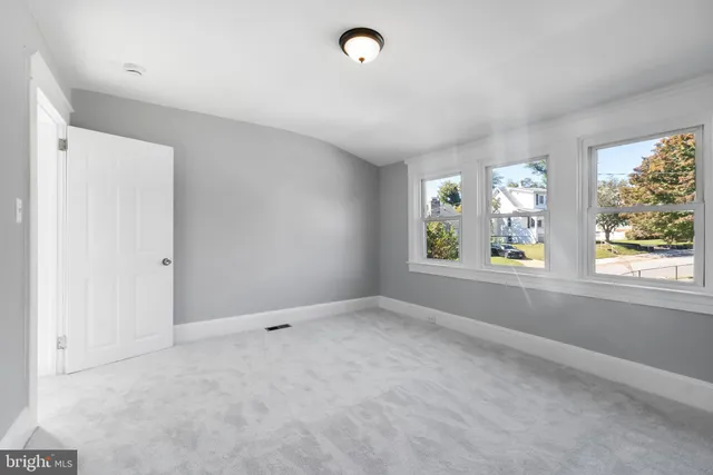 a view of a kitchen with white cabinets and white walls