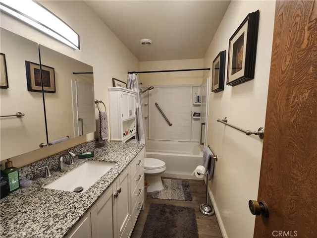 a bathroom with a granite countertop sink toilet and shower
