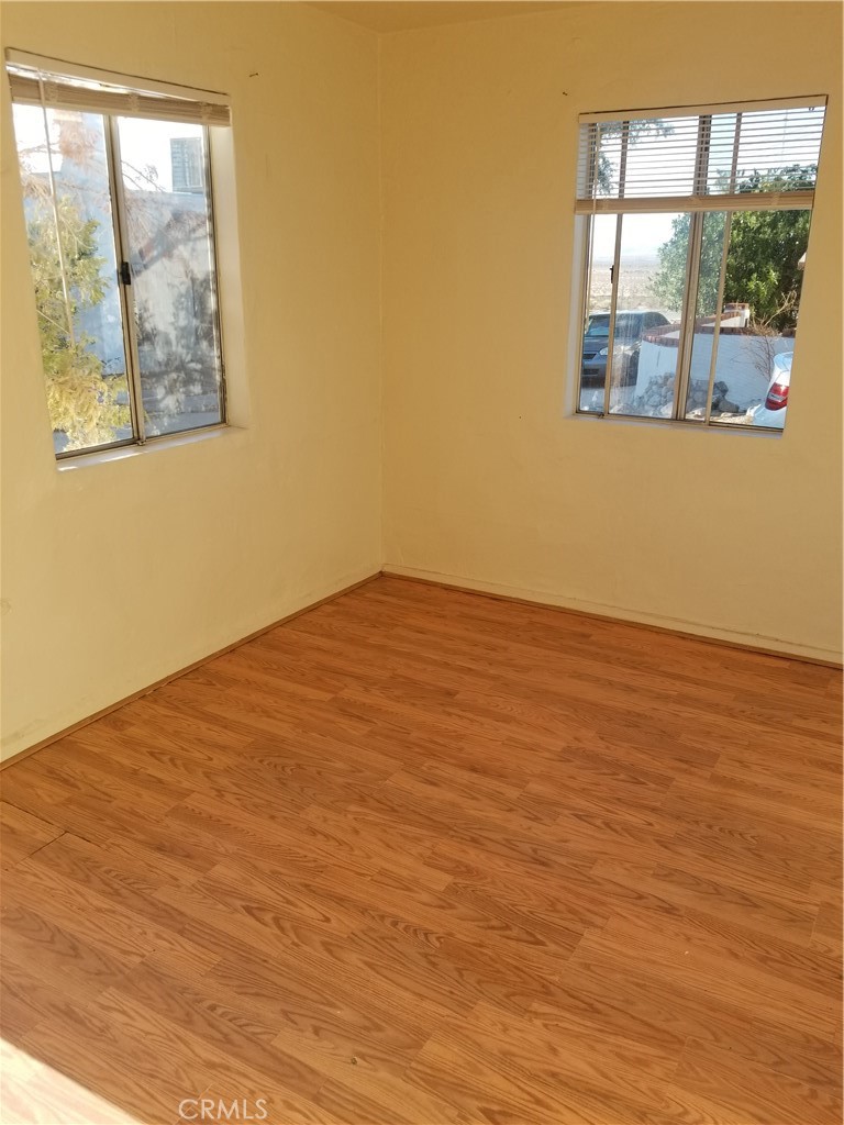 73550 2 Mile Road, Unit 11 Twentynine Palms, CA 92277 - Photo 5 of 7 an empty room with wooden floor and a window