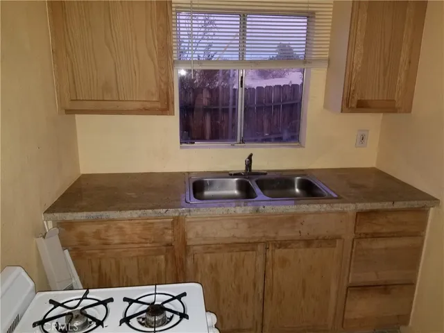 a kitchen with a sink a stove and a window