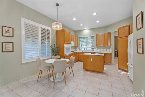 a large kitchen with kitchen island granite countertop a stove a sink a table and chairs