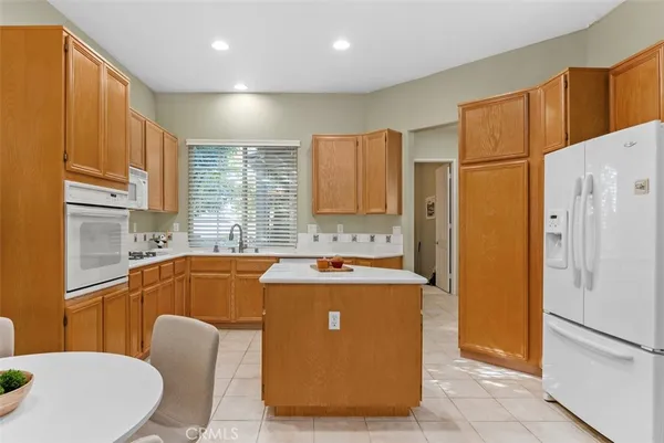 a kitchen with stainless steel appliances granite countertop a refrigerator a sink and a stove