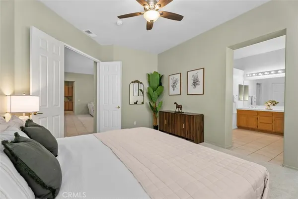 a bedroom with a large bed and ceiling fan