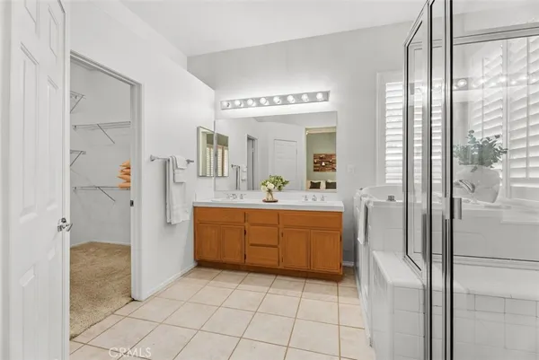 a large bathroom with a glass door shower a sink and a mirror