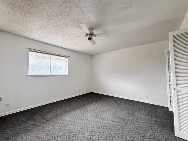 an empty room with a window and a ceiling fan