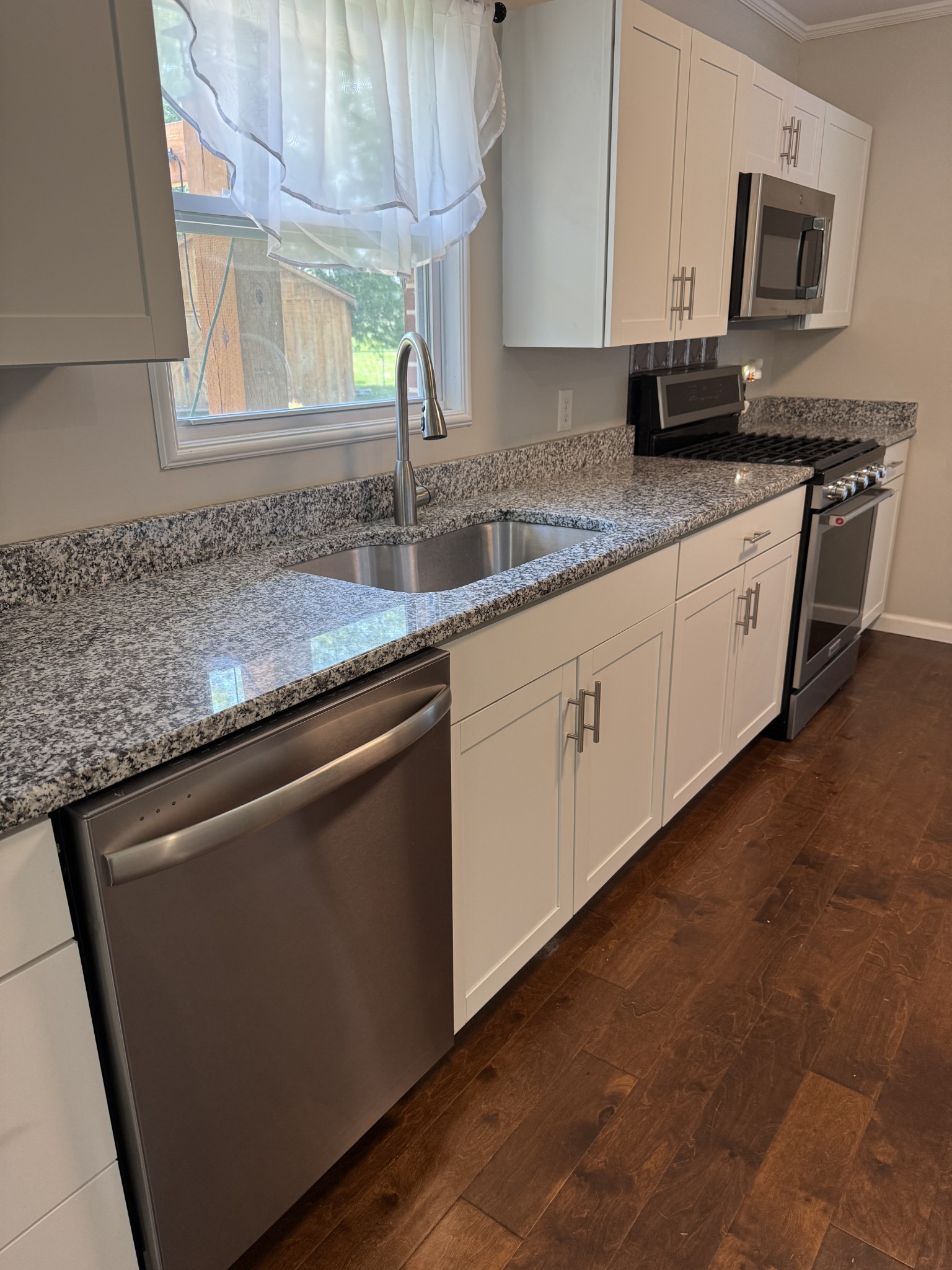8298 Southfork Road Baxter, TN 38544 - Photo 16 of 49 a kitchen with stainless steel appliances granite countertop a sink a stove and a microwave