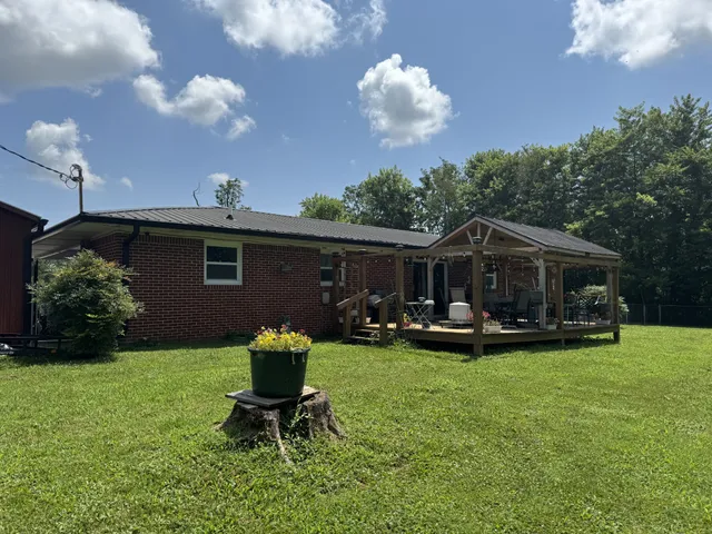 a view of a house with backyard sitting area and garden