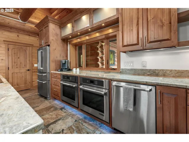 a kitchen with stainless steel appliances granite countertop a sink and a refrigerator