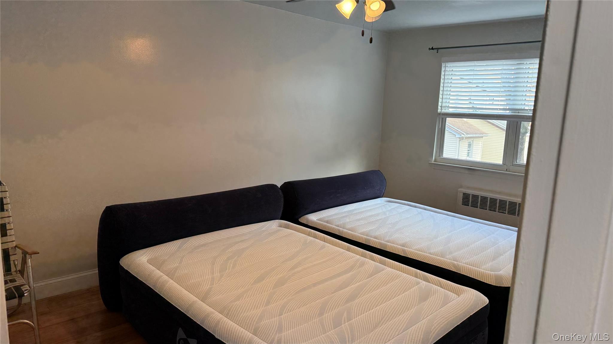 215-10 Hillside Avenue, Unit 1 Queens, NY 11427 - Photo 4 of 8 a bedroom with a bed and a window