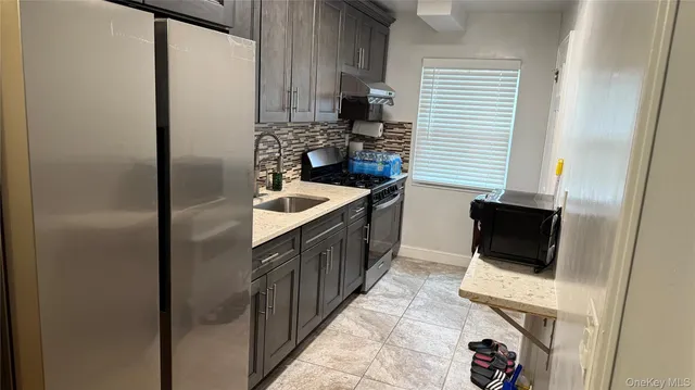 a kitchen with stainless steel appliances granite countertop a refrigerator and a stove