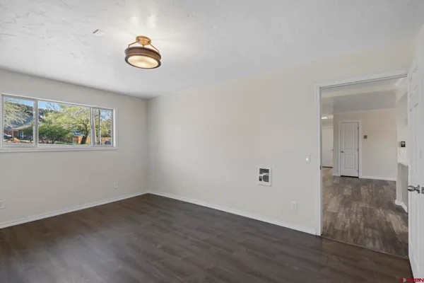 an empty room with wooden floor and window