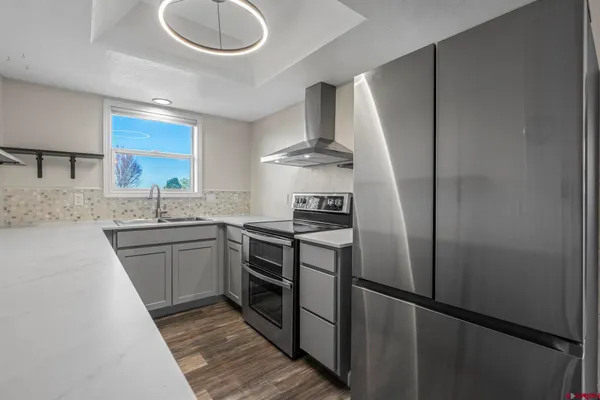 a kitchen with stainless steel appliances granite countertop a sink stove and refrigerator
