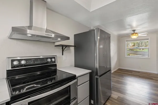 a view of kitchen with wooden floor and electronic appliances