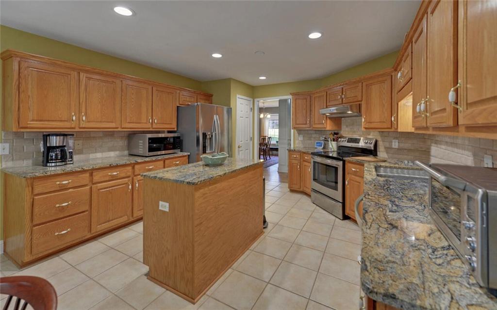 3644 Maple Forge Lane Gainesville, GA 30504 - Photo 15 of 49 a kitchen with kitchen island granite countertop a sink counter top space appliances and cabinets