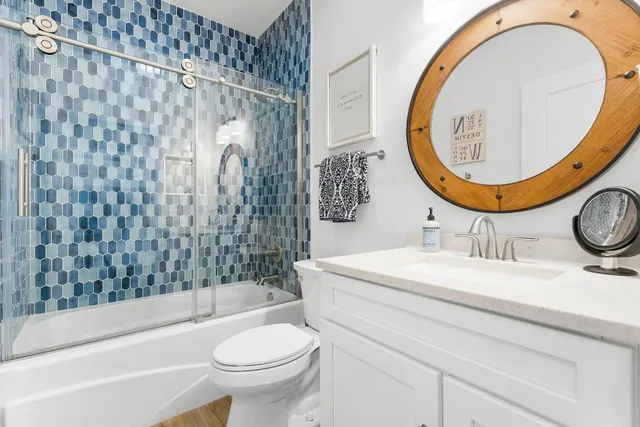 a bathroom with a sink a mirror a toilet and a tub