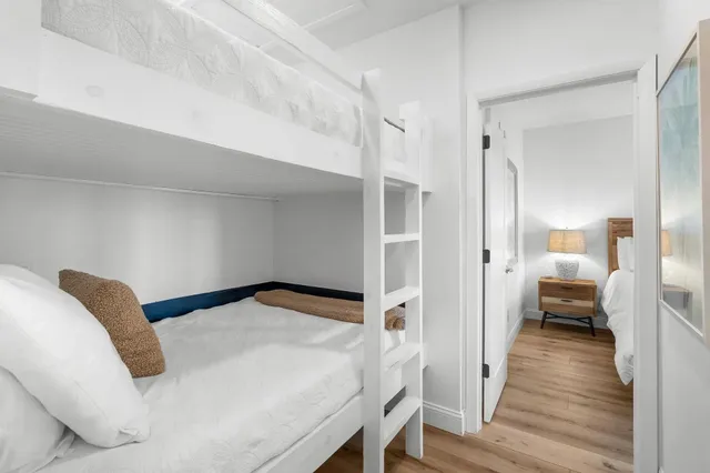 a view of a bedroom with wooden floor