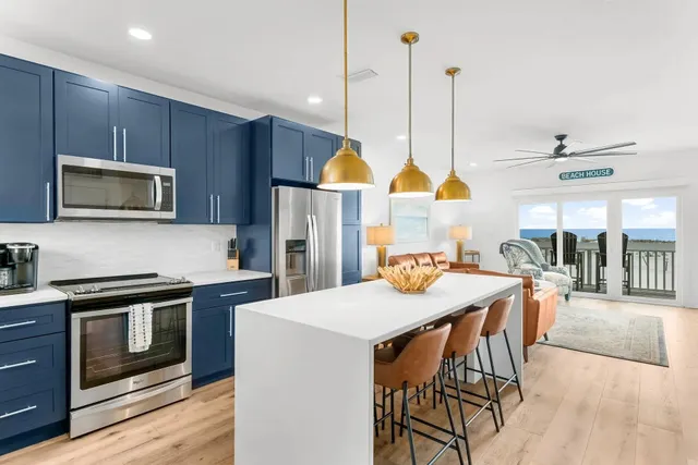 a kitchen with a stove a sink a microwave a dining table and chairs