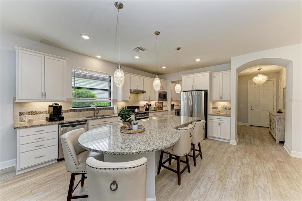 7572 Viola Loop Bradenton, FL 34202 - Photo 16 of 65 a kitchen with refrigerator a stove a sink and chairs