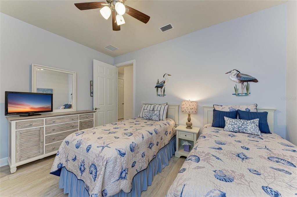 7572 Viola Loop Bradenton, FL 34202 - Photo 33 of 65 a bedroom with a bed and a chandelier