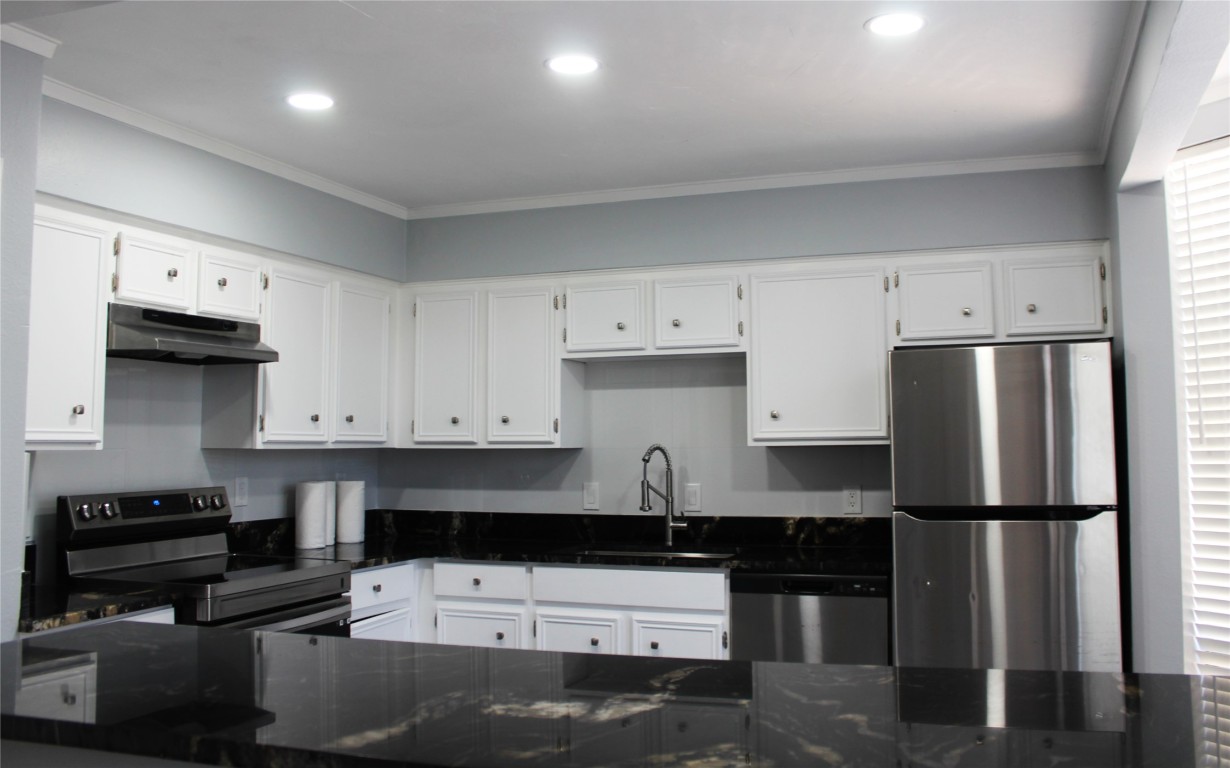 108 World Of Tennis Square, Unit 108C Lakeway, TX 78738 - Photo 5 of 25 a kitchen with a refrigerator and a stove